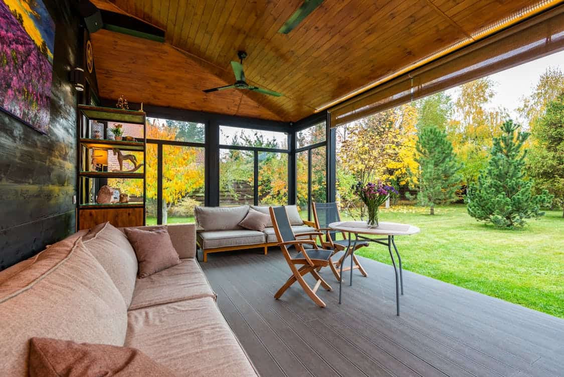 Terrace with comfortable couches and armchairs around table - Do Porches Add Value to a Home? Here’s the Truth