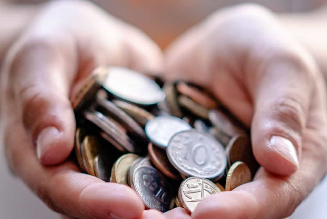 a person holding coins - What Is Sadaqah in Islam? Discover Its Real Meaning