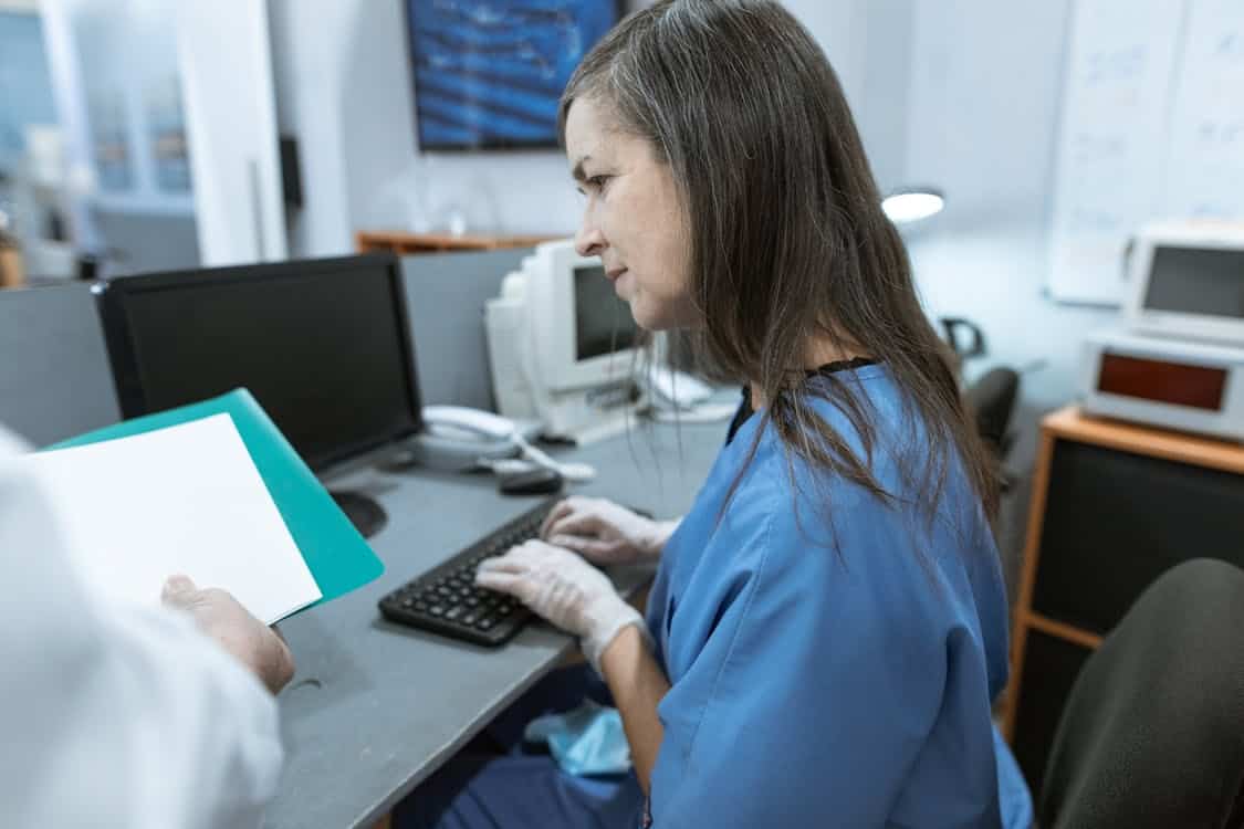 a nurse typing on keyboard - Falling Behind on Imaging Tech? Here&rsquo;s the Fix You Need
