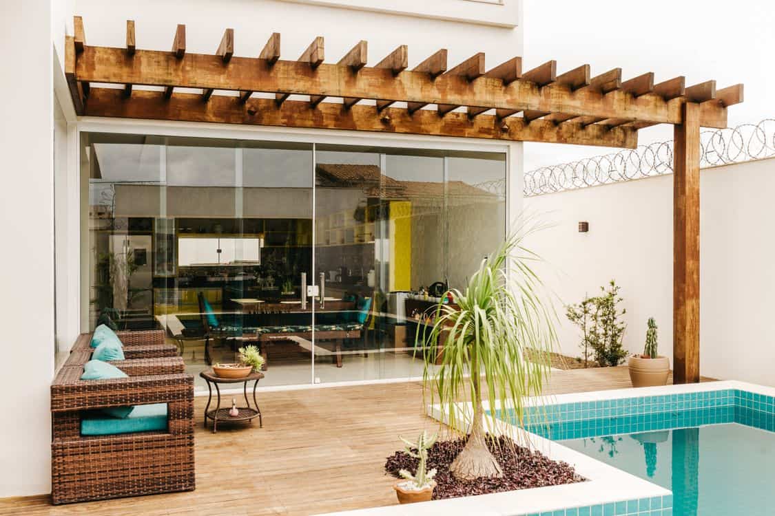 Stylish outdoor patio with wooden pergola and poolside lounge chairs - Las Vegas's Useless-Grass Deadline Is Sending Homeowners Toward Pergolas and Patio Covers